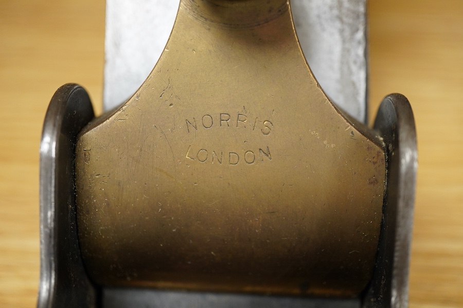 A Norris adjustable smoothing plane, stamped with Norris, London to the brass lever cap, with replacement iron, owner’s name lightly stamped to both sides of the handle, the front infill with a screw inserted down throug